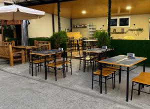 a group of tables and chairs in a restaurant at Salo Pool Hotel by the Sea in Gonio