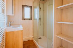 a bathroom with a sink and a shower at Village Vacances de Combelles in Le Monastère