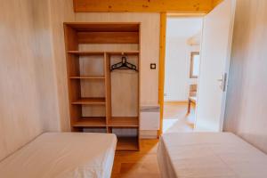 a bedroom with two beds and a closet at Village Vacances de Combelles in Le Monastère +12 photos