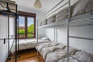 a bedroom with two bunk beds and a window at Little Yellow House in Gijón