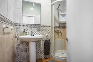 a bathroom with a sink and a shower and a toilet at Little Yellow House in Gijón +20 photos
