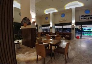 a restaurant with tables and chairs in a building at Golden Moon Apart Hotel in Kuşadası