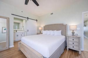 a bedroom with a large white bed and a bathroom at Phoenix VI 61115 in Orange Beach