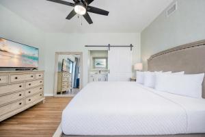 a bedroom with a white bed and a ceiling fan at Phoenix VI 61115 in Orange Beach +67 photos