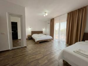 a hotel room with two beds and a mirror at Vila Diana in Venus