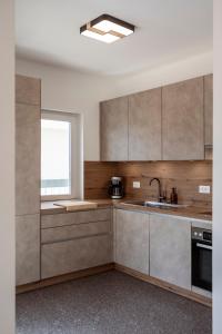 a kitchen with wooden cabinets and a window at Villa Tadini JOY in Babići
