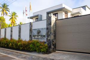 a building with a fence with a sign on it at Breedon Residence Hotel in Anuradhapura