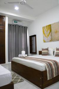 a bedroom with two beds and a painting on the wall at Breedon Residence Hotel in Anuradhapura
