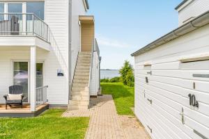 a white house with a patio and a balcony at Ferienwohnung WeitBlick Olpenitz in Olpenitz