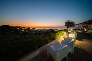 two white chairs sitting on a balcony at sunset at Residence New Paradise in Tropea