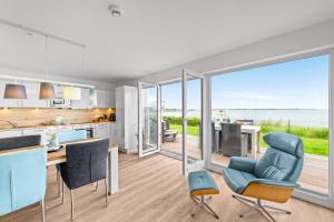 a kitchen and dining room with a view of the ocean at Ferienwohnung WeitBlick Olpenitz in Olpenitz