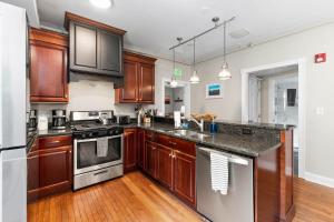 a kitchen with wooden cabinets and stainless steel appliances at TuckAway Suites at East Branch in Intervale