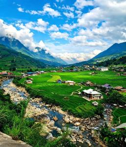 a small village next to a river with mountains at May Lai Homestay in Tả Van