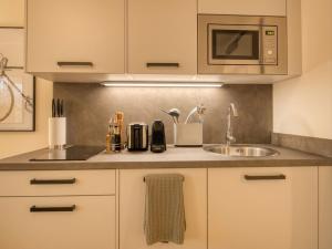 a kitchen with a sink and a microwave at Limehome München in Munich