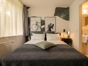 a bedroom with a bed with three pictures on the wall at Limehome München in Munich