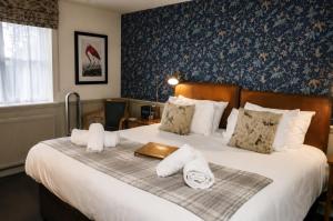a hotel room with a bed with towels on it at George Inn, Mere in Mere