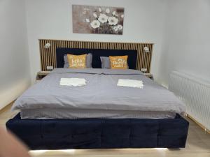 a bedroom with a large bed with orange pillows at Luna Studio in Hunedoara