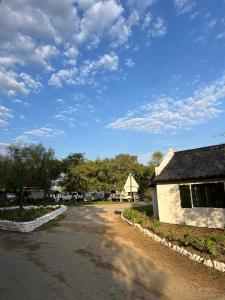 a dirt road next to a building and a barn at Kliprivier Park Tulbagh in Tulbagh +13 photos