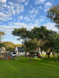 a tent in a field with trees and a house at Kliprivier Park Tulbagh in Tulbagh
