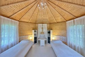 a bedroom with two beds and a wooden ceiling at Citi Krasti Eco Spa Residence in Kārļzemnieki