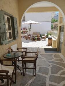 an outdoor patio with a table and chairs and an umbrella at Feidiou 1, vol I in Egina