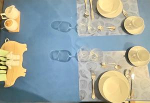 a table with glasses and plates and cutlery on it at Room Lina in Lovran