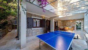 a ping pong table in the middle of a patio at Waterfront Villa Dora by Villas Guide in Smokvica