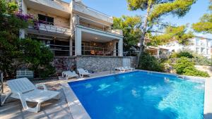 a swimming pool in front of a house at Waterfront Villa Dora by Villas Guide in Smokvica