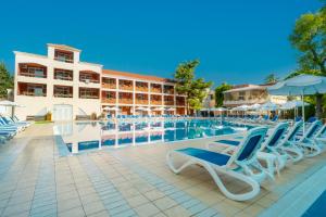 a pool with blue and white chairs and a building at Asteria Family Sunny Beach - Ultra All Inclusive in Sunny Beach