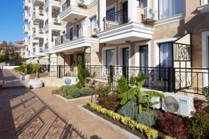 a building with balconies and plants on a street at Polarstar Beach Resort - Premium Apartments in Sveti Vlas