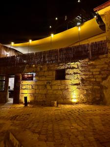 an old stone building with lights on it at night at Asma Altı Cave in Nar