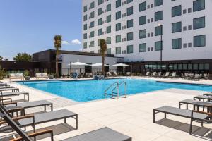 a swimming pool with chairs and a building at EVEN Hotel Orlando Universal Blvd by IHG in Orlando