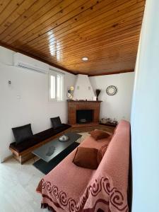 a bedroom with a bed and a couch and a table at Sisyphys Kingdom in Korinthos