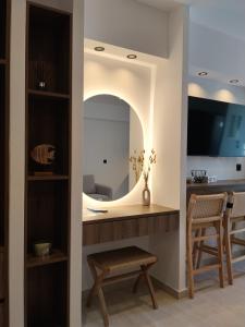 a living room with a mirror and a chair at Milea amare Suites in Adamantas
