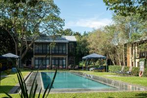 a swimming pool in front of a house at Casterbridge Hollow Boutique Hotel in White River
