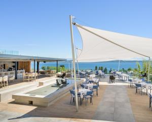 a restaurant with tables and chairs on a deck at Hôtel Alpes & Lac in Neuchâtel