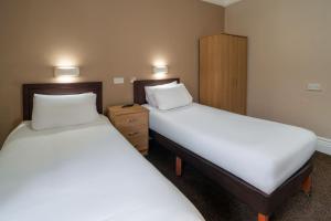 two beds in a small room with two beds sidx sidx sidx at The Grand Hotel in Llandudno +19 photos