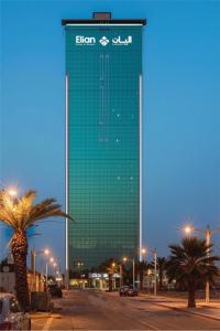 a tall green building with a sign on it at Elian Tower AlSahafa Hotel in Riyadh