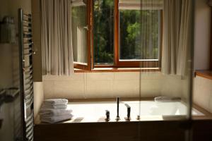 a bathroom with a sink and a window and towels at SPA VILNIUS Anykščiai in Anykščiai