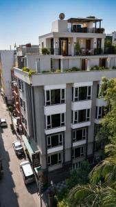 a large white building with cars parked in front of it at Hotel Sopan Heights in New Delhi