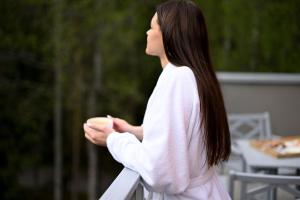 a woman in a white sweater holding a bowl of food at SPA VILNIUS Anykščiai in Anykščiai
