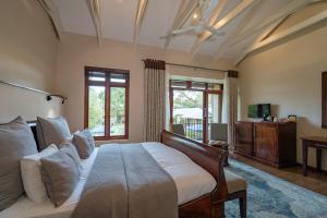 a bedroom with a large bed and a window at Casterbridge Hollow Boutique Hotel in White River +62 photos