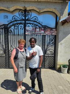 a man and a woman standing in front of a gate at Casa Taraneasca "OM BUN" in Alămor