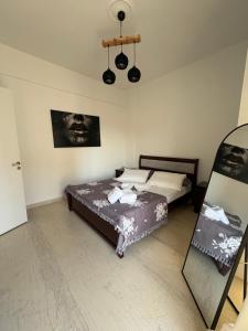 a bedroom with two beds and a painting on the wall at Sisyphys Kingdom in Korinthos