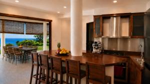 a kitchen with a table with a bowl of fruit on it at Villa Layar with Private Pool and Ocean View in Lajor