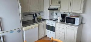 a small kitchen with white cabinets and a microwave at Pankkikallio 16 in Sorsakoski