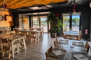 a restaurant with wooden tables and chairs and windows at Kampaoh Âncora in Vila Praia de Âncora