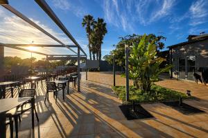 a patio with tables and chairs and a plant at Kampaoh Âncora in Vila Praia de Âncora