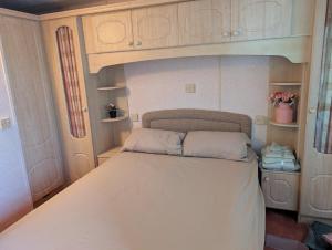 a small bedroom with a bed in a room at Caravan 68 The Vale in Fishguard