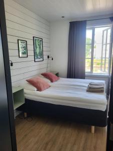 a bedroom with a large bed with two pillows and a window at Villa Korsman in Hanko